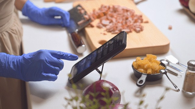 니트릴 장갑을 낀 채로 휴대폰 화면을 만지는 모습